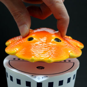 耳を掴んで持ち上げます カップメンダコ【カップらーめんのフタ】